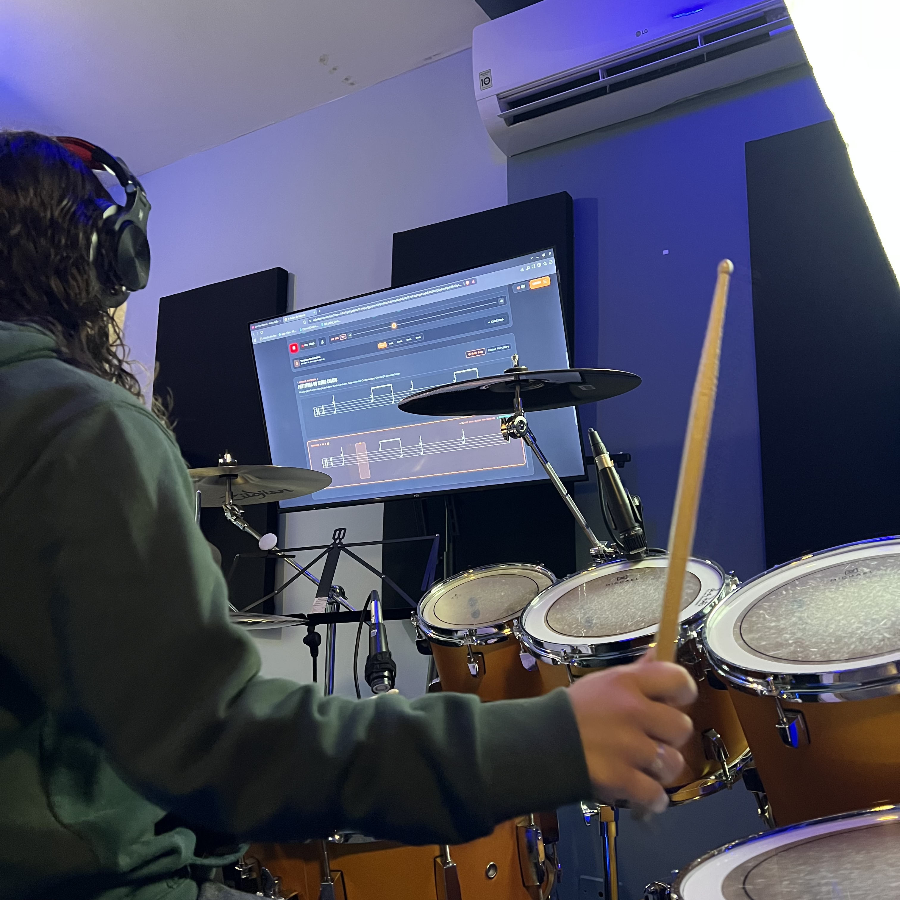 Aulas de bateria em Londrina com monitor de vídeo na frete das baterias para auxiliar nas aulas
